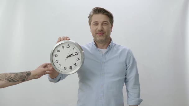 Характерний Портрет Молодої Людини Тримає Великий Настінний Годинник Чоловік Показує — стокове відео