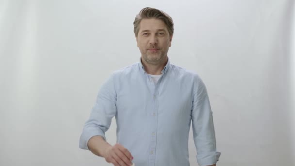Mann Steht Vor Weißem Hintergrund Und Zeigt Den Schlüssel Seinem — Stockvideo