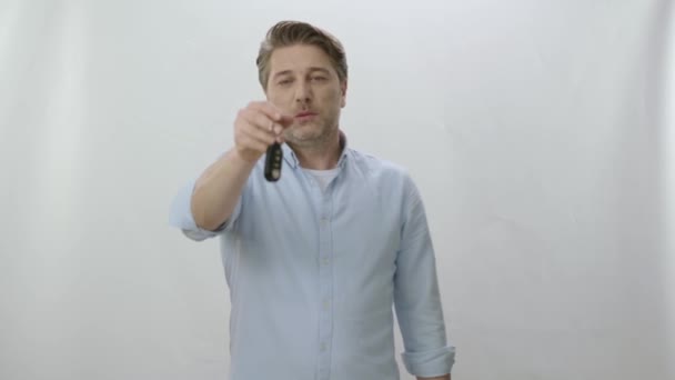 Aufgeregte Junge Mann Zeigt Schlüssel Seinem Neuen Auto Isoliert Auf — Stockvideo
