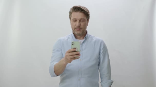 Young Man Spends Time Internet His Smartphone White Background Man — Stock Video