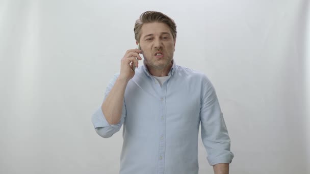 Θυμωμένος Και Απογοητευμένος Καυκάσιος Νεαρός Μιλάει Στο Τηλέφωνο Απομονωμένος Λευκό — Αρχείο Βίντεο