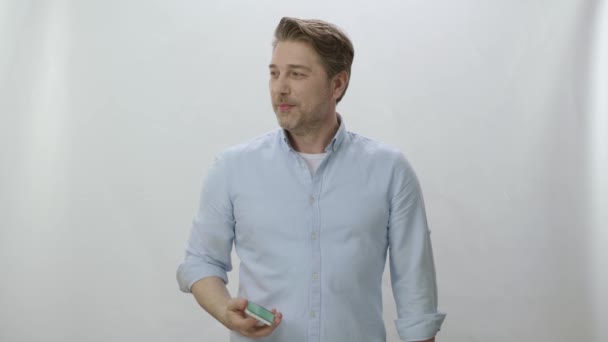 Młody Człowiek Patrząc Kropkę Lewej Stronie Ekranu Smartfonem Ręku Kreatywni — Wideo stockowe