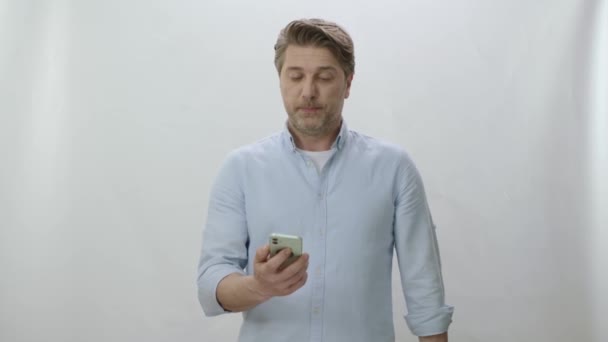 Χαμογελώντας Ώριμος Επιχειρηματίας Απομονωμένος Λευκό Φόντο Κρατώντας Ένα Smartphone Αυτοπεποίθηση — Αρχείο Βίντεο
