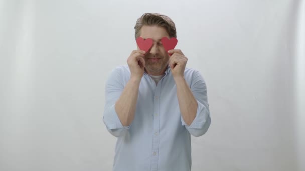 Feliz Hombre Sonriente Sosteniendo Corazón Papel Sus Ojos Aislados Sobre — Vídeo de stock
