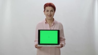 Yeşil ekranlı dizüstü bilgisayar tutan mutlu iş kadınının portresi. Çalışkan mutlu iş kadını beyaz arka planda izole edilmiş teknolojiyi kullanmaktan zevk alıyor..