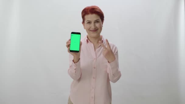 Рыжая Женщина Показывает Смартфон Зеленым Экраном Белом Фоне Игрок Женщина — стоковое видео