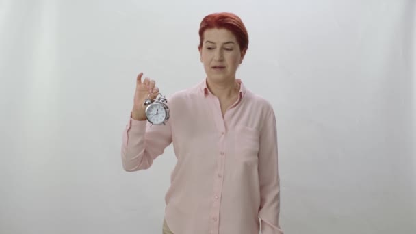 小さな机の時計を持っている女性の文字の肖像画 女は時間が経過したことを示し時間をうまく使う必要がある 女性は高齢化に注意を引く — ストック動画