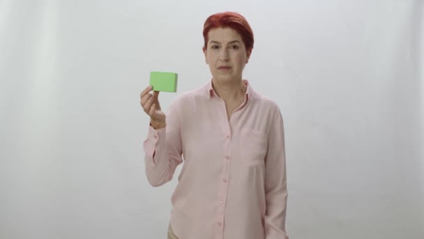 Studio Πορτρέτο Μιας Κοκκινομάλλας Γυναίκας Λευκό Φόντο Γυναίκα Δείχνει Προϊόν — Αρχείο Βίντεο