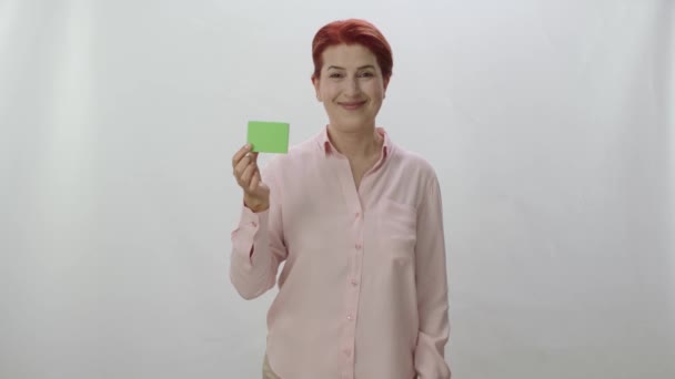 Studio Πορτρέτο Μιας Κοκκινομάλλας Γυναίκας Λευκό Φόντο Γυναίκα Δείχνει Προϊόν — Αρχείο Βίντεο