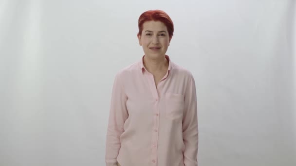 若い美しい女性のカメラで不幸な 怒って笑顔を見て 白い背景に隔離された美しい赤い髪の女性の幹部 自信ある女性の肖像画 — ストック動画