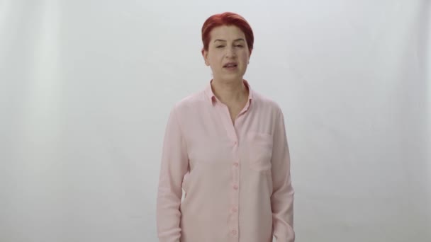 画面右側の広告スペースで2本の指で指差す赤い髪の女性 ジェスチャーを右にスワイプします 女が白い背景を指差す所に置きたいものは何でもいい — ストック動画