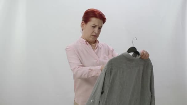 Женщина Проверяет Пятна Свежевыстиранной Одежде Изолированной Белом Фоне Удивлена Увидев — стоковое видео