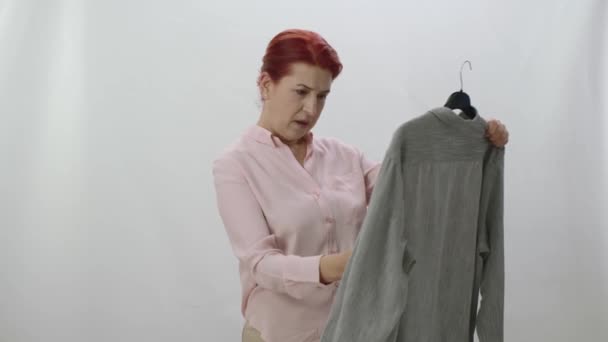 Γυναίκα Ελέγχει Λεκέδες Φρεσκοπλυμένα Ρούχα Απομονωμένη Λευκό Φόντο Είναι Έκπληξη — Αρχείο Βίντεο