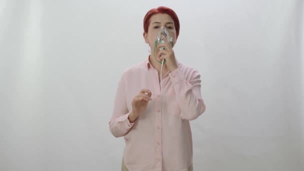 拿着蒙面雾化器的女人把烟雾药吸入肺里 带着呼吸面罩呼吸的生病妇女 在白色背景下被隔离 疾病概念 — 图库视频影像