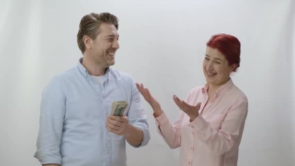Любящий Мужчина Белом Фоне Весело Жестикулирует Давая Деньги Своей Жене — стоковое видео