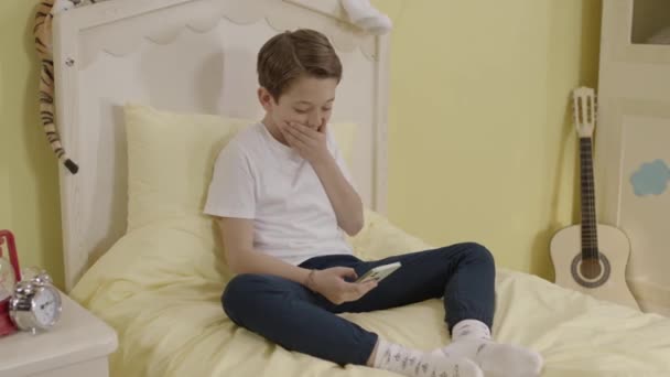 Menino Sentado Sua Cama Usando Smartphone Criança Está Jogando Jogos — Vídeo de Stock