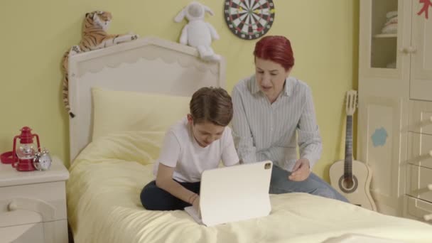 Neşeli Bir Annenin Oğluyla Yatakta Oturup Tablet Bilgisayarda Oyun Oynaması — Stok video