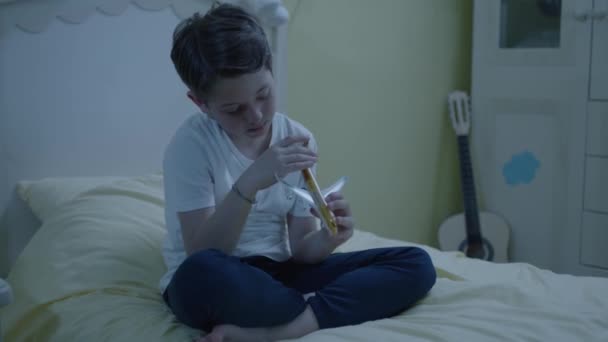 小男孩在他房间的床上玩着一架小型客机模型 那个对飞机和飞行感兴趣的男孩 一个孩子一个人玩他的玩具 — 图库视频影像