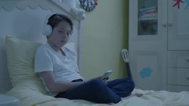 Bambino Che Ascolta Musica Con Smartphone Cuffie Nel Suo Letto — Video Stock