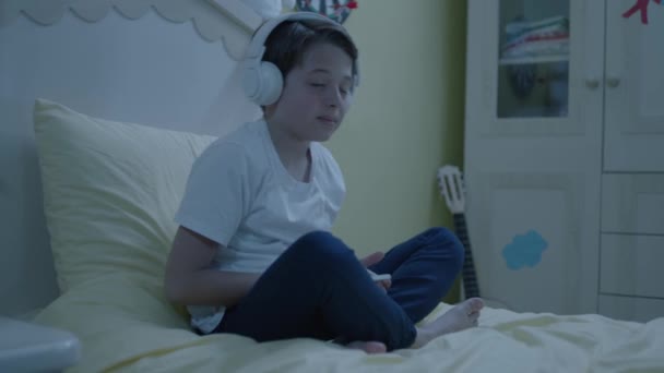 Menino Ouvindo Música Com Smartphone Fones Ouvido Sua Cama Criança — Vídeo de Stock