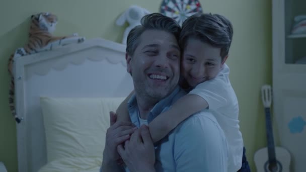 사랑스럽게 아버지를 포옹하는 소년의 소년은 아버지를 뒤에서 아버지는 아들을 껴안고 — 비디오