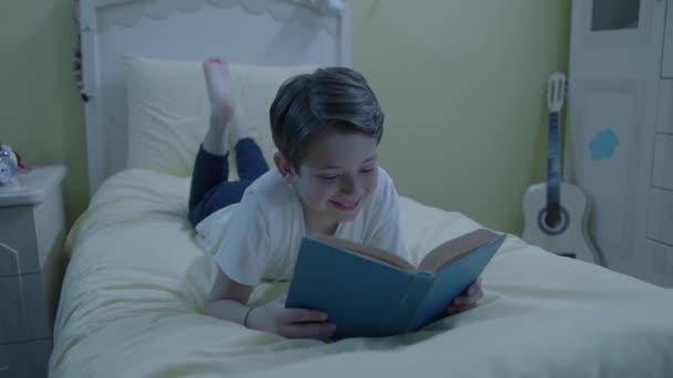 Anak Kecil Membaca Buku Tempat Tidur Kamar Tidur Malam Hari — Stok Video