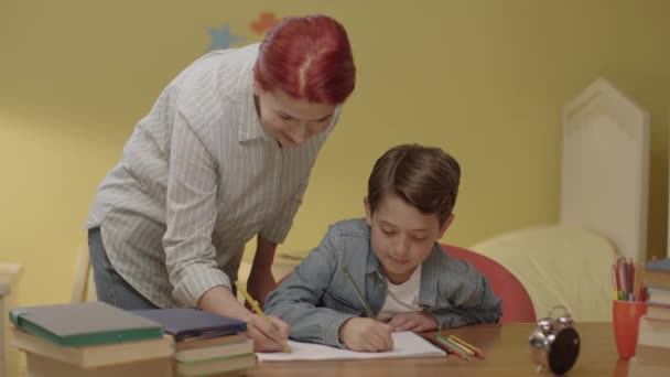 Junge Mutter Hilft Ihrem Kind Bei Den Hausaufgaben Eine Liebevolle — Stockvideo