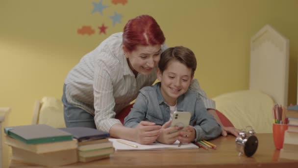 Młoda Matka Pomaga Dziecku Słuchać Prac Domowych Smartfonie Młoda Kochająca — Wideo stockowe
