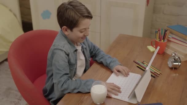 Kleine Jongen Drinkt Melk Tijdens Zijn Lessen Tablet Computer Hij — Stockvideo