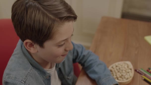 Der Kleine Junge Isst Haselnüsse Erdnüsse Oder Walnüsse Während Seinen — Stockvideo