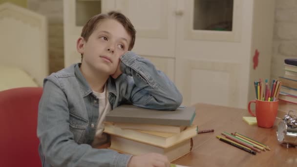 勉強に飽き飽きしている少年 彼の部屋の机に座っていた少年は 疲労から読んでいた本の中で眠ってしまった 試験準備の概念 — ストック動画