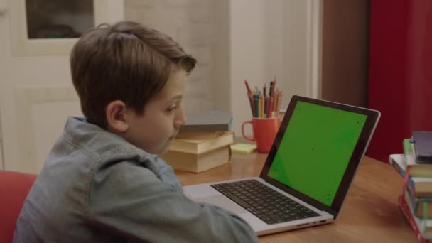 Kisiskolás Diák Online Dolgozik Otthonról Laptopon Zöld Képernyővel Hallgatja Tanárokat — Stock videók