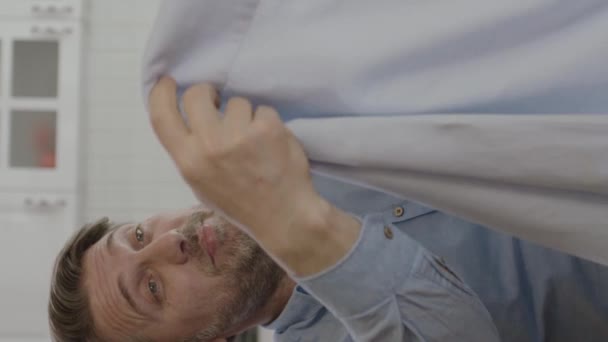 Joven Buscando Manchas Camisa Recién Lavada Hombre Está Olfateando Camisa — Vídeo de stock