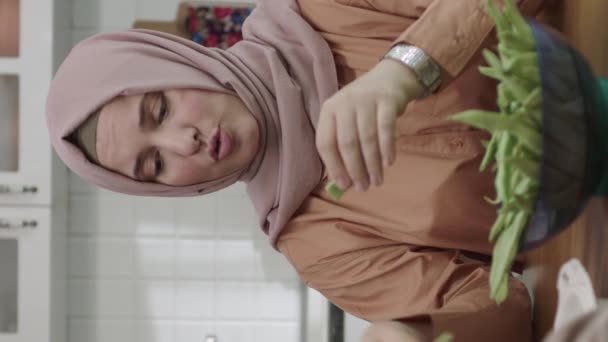 Młoda Kobieta Hidżabie Czyści Zieloną Fasolę Podczas Rozmowy Swoją Teściową — Wideo stockowe