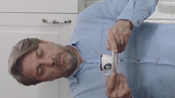 自宅でコーヒーを飲む男は彼のコーヒーをこぼす コーヒーをこぼさないしようとしている男 垂直ストーリーのためのビデオ — ストック動画
