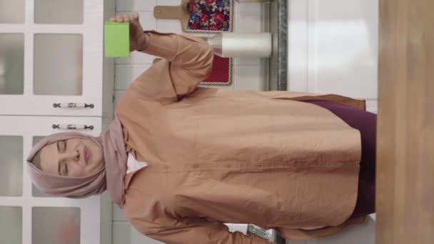 Kobieta Hidżabie Trzyma Coś Zielonego Kuchni Pokazując Produkt Kreatywni Artyści — Wideo stockowe