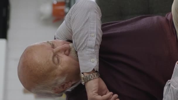 一位过敏的老年男子坐在家中的扶手椅上打喷嚏 过敏和流感症状 国内验尸和检疫时间的概念 垂直故事录像 — 图库视频影像
