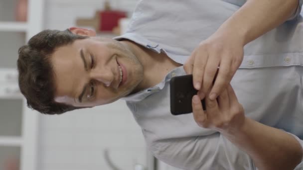 Счастливый Молодой Человек Смотрит Мобильный Телефон Дома Счастлив Получить Деньги — стоковое видео