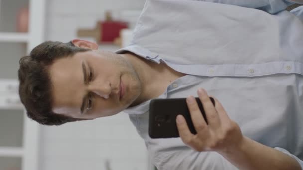 옷차림을 남자가 소파에서 스마트폰을 사용하는 청년의 모바일 사용자는 디지털 개발하고 — 비디오