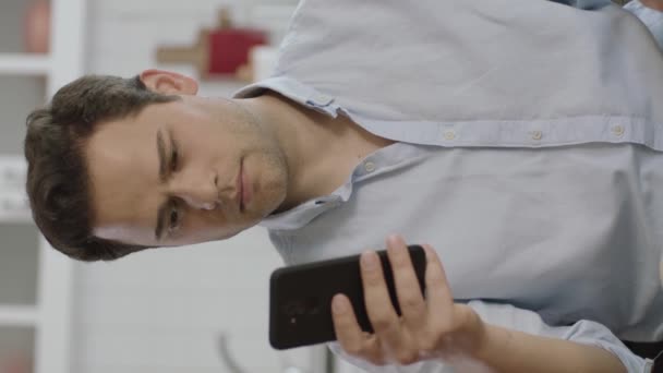 옷차림을 남자가 소파에서 스마트폰을 사용하는 청년의 모바일 사용자는 디지털 개발하고 — 비디오