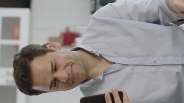 Knappe Opgewonden Jonge Man Zit Bank Thuis Met Smartphone Scherm — Stockvideo