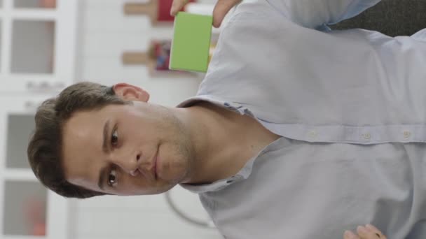 Jeune Homme Tenant Quelque Chose Vert Montrant Produit Souriant Présentant — Video