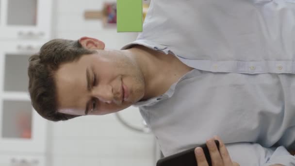 Mężczyzna Trzymający Smartfona Coś Zielonego Sofie Pokazując Produkt Uśmiechając Się — Wideo stockowe