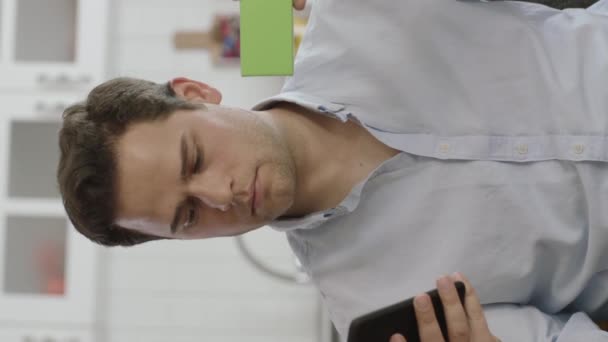 Man Håller Smartphone Och Något Grönt Sin Soffa Visar Produkt — Stockvideo
