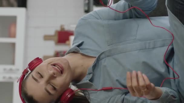 Mujer Sentada Sofá Con Auriculares Inalámbricos Para Escuchar Música Casa — Vídeo de stock