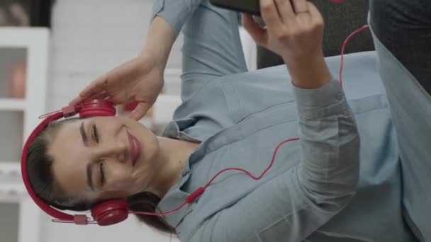 Mujer Sentada Sofá Con Auriculares Inalámbricos Para Escuchar Música Casa — Vídeos de Stock