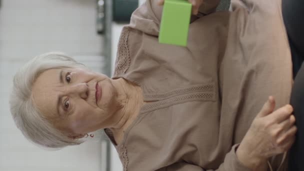 Anciana Sostiene Algo Verde Muestra Producto Sonríe Presenta Objeto Imaginario — Vídeos de Stock