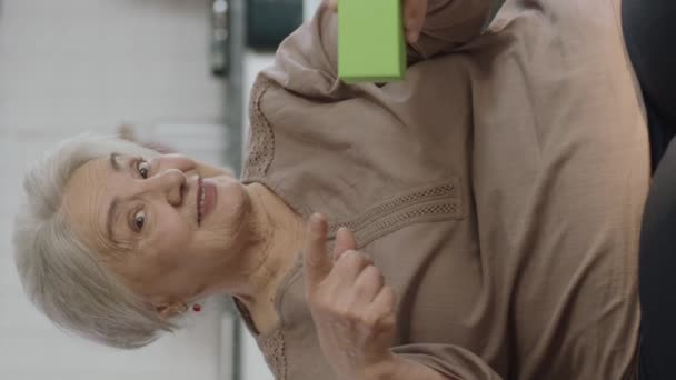Stará Žena Drží Něco Zeleného Ukazuje Produkt Usmívá Představuje Imaginární — Stock video