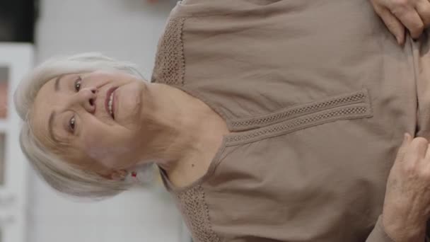 Усміхнена Старша Жінка Розслабляється Зручному Дивані Вітальні Дивлячись Камеру Усміхаючись — стокове відео