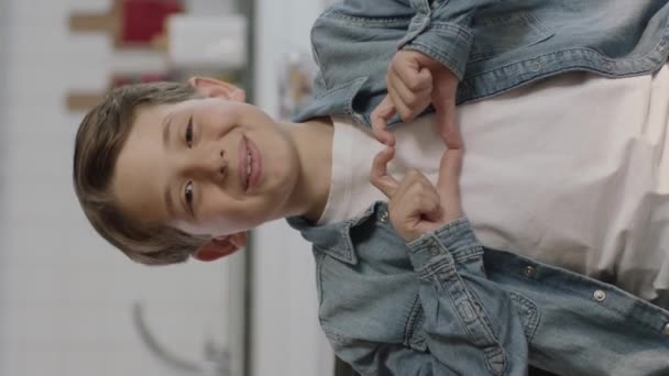 Cute Little Boy Sitting Sofa Giving Heart Shape Camera Hands — Stock Video